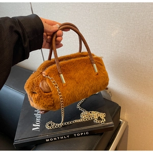 Detail of plush brown capybara bag with leather handle and golden metal chain strap