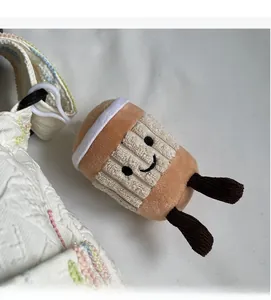 Detail of cute plush coffee cup keychain on a wide embroidered floral bag strap