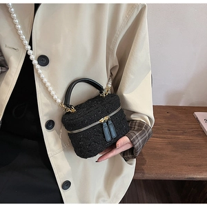 Détail du sac seau en tweed avec bandoulière en perles élégante et finitions dorées
