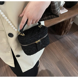 Détail du sac seau en tweed noir avec fils argentés et bandoulière en perles