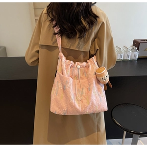 Pink quilted tote bag with embroidery, drawstring closure, and plush coffee cup charm