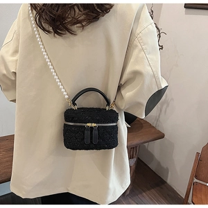Détail d'un sac en tweed avec bandoulière en perles et zip doré sur un mannequin