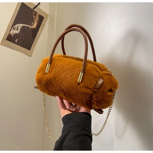 Close-up of caramel brown fluffy faux fur handbag with leather handles and gold chain