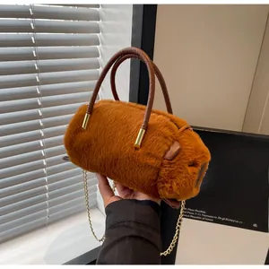 Detail of plush capybara shaped handbag with soft brown fur and gold metal chain strap