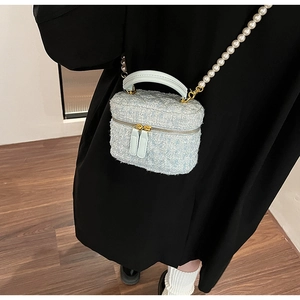 Vue détaillée du sac vanité en tweed bleu clair avec bandoulière perle et poignée verte