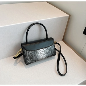 Detail of black and silver snakeskin texture contrast on a handheld crossbody bag