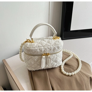 Détail du sac seau en tweed blanc avec sa bandoulière ornée de grandes perles nacrées