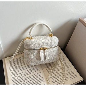 Détail du mini sac seau en tweed blanc avec poignée en cuir et chaîne en perles