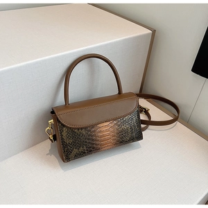 Detail shot of vintage crocodile pattern handbag with golden metal hardware and strap