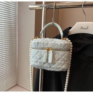 Détail du sac vanité en tweed vert menthe avec bandoulière perle et détails dorés