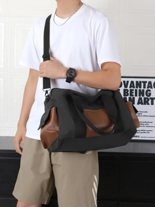 Large capacity black canvas travel bag with leather trim and wide shoulder strap