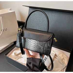 Detail of vintage crocodile texture bag with gold hardware in an elegant gift box setting