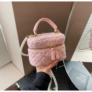 Détail du mini sac vanité en tweed rose avec bandoulière perles et finitions dorées