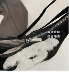 Détail de la fermeture éclair en métal argenté lisse sur le sac à bandoulière en nylon