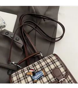 Detail of brown plaid crossbody bag with sausage dog embroidery and adjustable slim strap