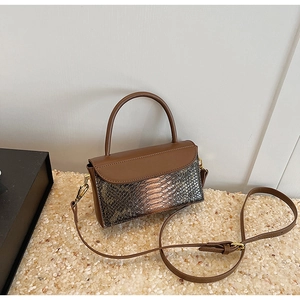 Detail of vintage brown crocodile texture handbag with gold metal hardware and top handle