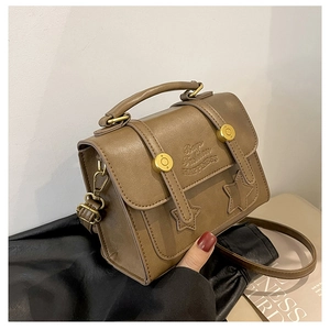 Detailed view of brown vintage crossbody bag with star embossing and gold hardware