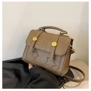 Close-up of vintage brown PU leather bag with star embossing and gold details