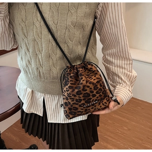 Detail shot of leopard print bucket bag featuring CLEAR-K logo and drawstring closure