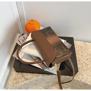 Detailed view of the brown embossed crocodile texture and gold hardware on this handbag