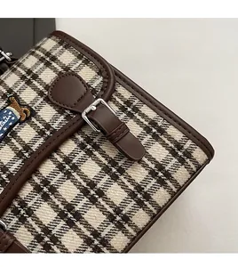 Detail of plaid fabric backpack with leather trim and cute bear embroidery patch