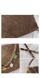 Detail of dark brown suede bucket bag featuring star quilting and gold chain strap