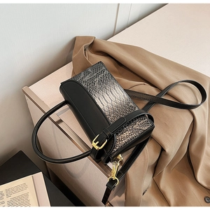 Detail of snake skin texture and golden hardware on a vintage crossbody handbag