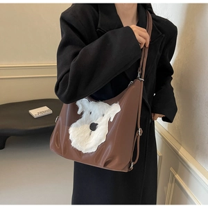 Détail d'un sac hobo marron avec broderie Schnauzer en peluche blanche et bandoulière réglable