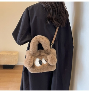 Detail der braunen Plüschtasche mit süßer Cartoon-Augenstickerei und Goldbeschlägen