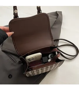 Interior view of brown plaid crossbody bag showing storage for phone and wallet