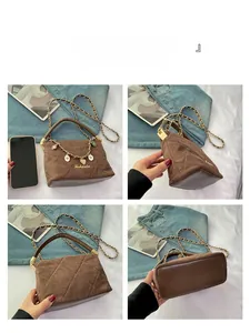 Angle display showing brown suede quilted crossbody bag with gold heart chain and strap