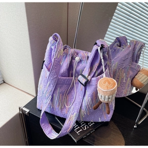 Detail of purple tote bag with colorful radial embroidery and embossed texture