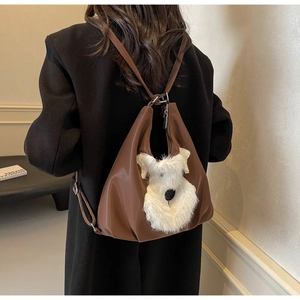 Détail d'un sac à bandoulière en cuir marron avec broderie de chien en peluche blanche