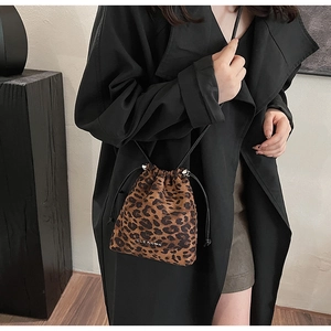 Detail of leopard print bucket bag with drawstring closure and CLEAR-K logo on black coat