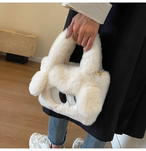 Detailansicht der weißen Plüschtasche mit Cartoon-Augen-Stickerei und flauschigen Ohren