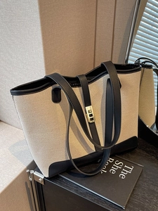 Canvas contrast tote bag with black leather trim and top handle in a minimalist style