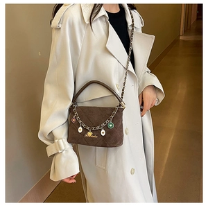 Detailed shot of dark brown frosted quilted bucket bag with golden heart chain charms