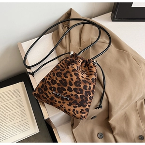 Gros plan du sac seau léopard avec logo métallique CLEARMK et fermeture à cordon
