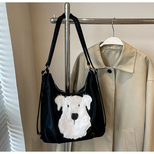 Détail du cabas noir avec écusson chien en peluche blanche et bandoulière réglable