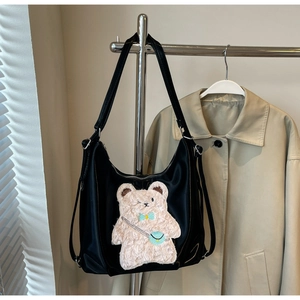 Détail d'un sac cabas noir avec broderie ours en peluche 3D et bandoulières réglables