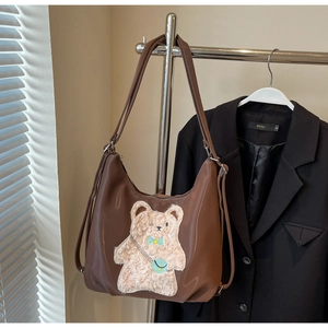 Sac fourre-tout en similicuir marron avec broderie d'ours en peluche sous la lumière