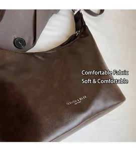Detail of dark brown leather hobo bag with Fashion & Bags printed text on soft matte finish