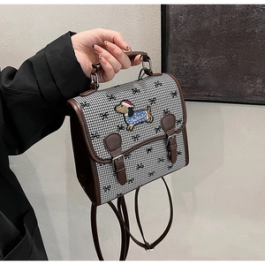 Close-up of mini houndstooth bag featuring a dachshund embroidery with holiday hat