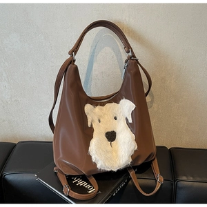 Détail d'un sac cabas marron avec broderie de chien en peluche blanche et texture brillante