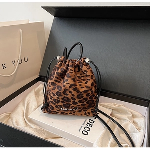 Détail du sac seau à imprimé léopard avec logo clear présenté dans une boîte cadeau