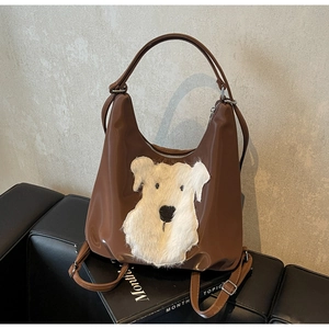 Détail du sac cabas marron avec écusson de chien en peluche et bandoulières