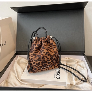 Détail du sac seau en daim léopard avec cordon en cuir et fermoir en métal argenté