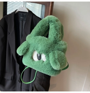 Detailaufnahme der grünen Plüschhandtasche mit flauschiger Textur und Cartoon-Augen