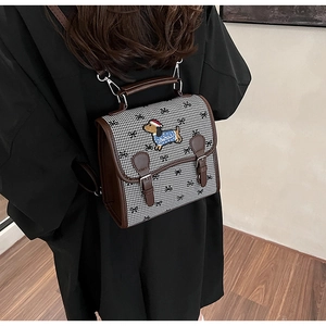 Close-up of checkered crossbody bag with dachshund embroidery and brown leather trim