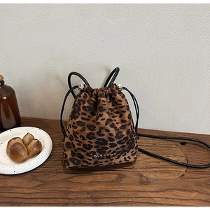 Détail du sac seau à imprimé léopard avec cordon de serrage et boules en métal argenté